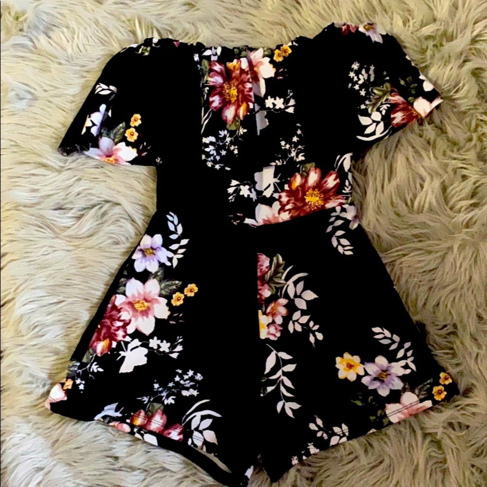 A flowered romper with a ruffle over the top.